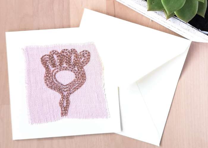Abstrakte Pflanzenkarte handgestickt mit Kettenstich auf rosa Leinenstoff